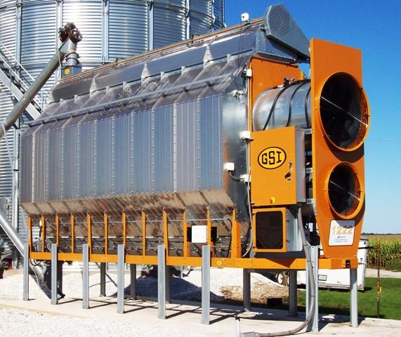 A GSI grain dryer next to a grain silo.